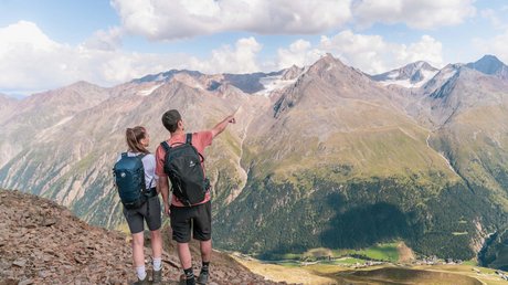 Des impressions de notre hôtel alpin à Vent ! Deux randonneurs avec sacs à dos regardent un paysage de montagne avec des nuages