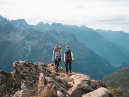 Wandern in den Ötztaler Alpen: von Ihrem Hotel in die Berge Zwei Wanderer mit Rucksäcken auf Bergpfad vor Alpenpanorama