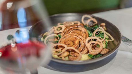 Des impressions de notre hôtel alpin à Vent ! Plat gastronomique avec champignons, rondelles d'oignon frites et légumes dans un bol noir