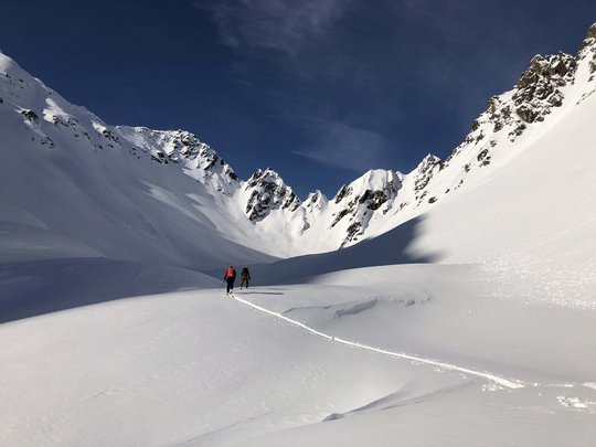 Skitouren rund um Vent: direkt von Ihrem Hotel in die Berge Zwei Skifahrer in schneebedecktem Tal unter blauem Himmel