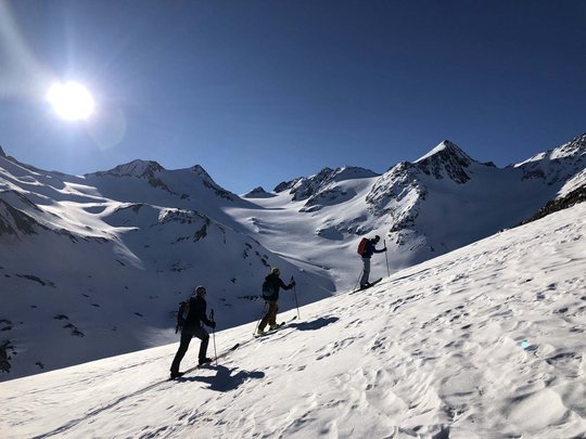 Skitouren rund um Vent: direkt von Ihrem Hotel in die Berge Drei Skitourengeher steigen bei sonnigem Wetter auf schneebedecktem Berg auf