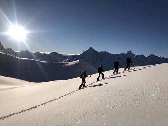 Skitouren rund um Vent: direkt von Ihrem Hotel in die Berge Vier Skitourengeher steigen bei Sonnenschein in verschneiten Bergen auf