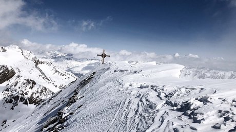 Des impressions de notre hôtel alpin à Vent ! Sommet de montagne enneigé avec croix en bois sous un ciel bleu