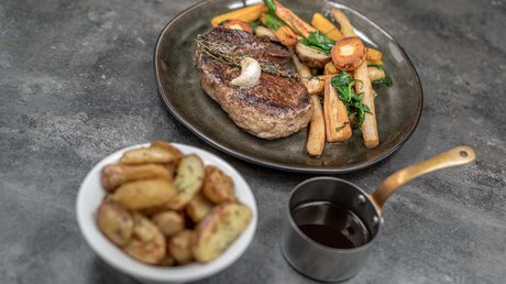 Des impressions de notre hôtel alpin à Vent ! Steak avec légumes rôtis, pommes de terre et sauce au jus dans une assiette foncée