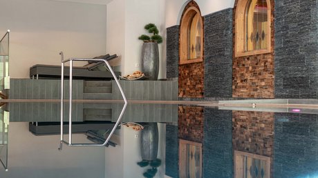 Des impressions de notre hôtel alpin à Vent ! Piscine intérieure avec chaises longues et murs avec fenêtres décoratives en bois