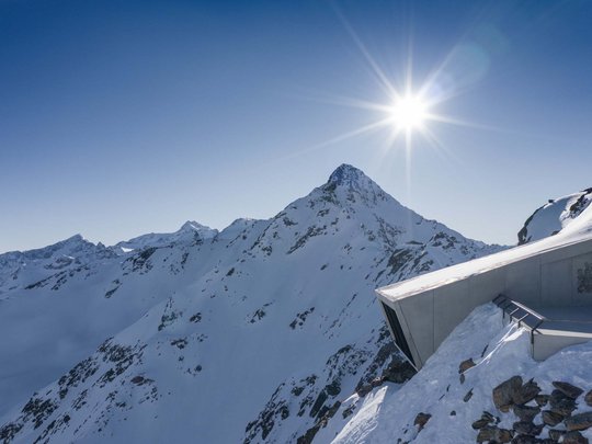 Natur- und Alpinhotel Post: Sehenswürdigkeiten im Ötztal Sonniger Tag auf schneebedeckten Bergen mit modernem Gebäude am Abhang