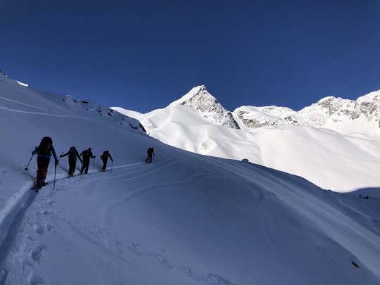 Skitouren rund um Vent: direkt von Ihrem Hotel in die Berge Gruppe von Skitourengehern auf verschneitem Bergweg bei klarem Himmel