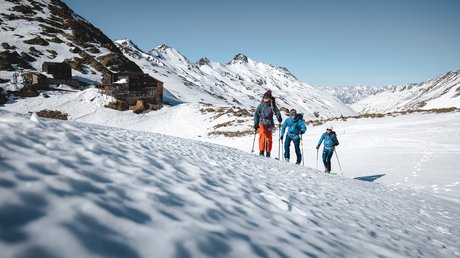 Des impressions de notre hôtel alpin à Vent ! Trois randonneurs en montagne enneigée près d'un refuge et des sommets alpins