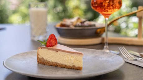 Des impressions de notre hôtel alpin à Vent ! Une part de cheesecake avec une fraise sur une assiette grise