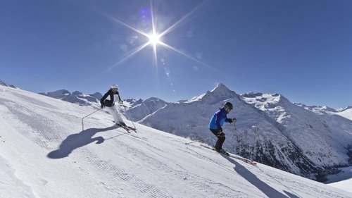 Neues und Wissenswertes aus Vent Zwei Skifahrer fahren bei sonnigem Wetter in den verschneiten Bergen