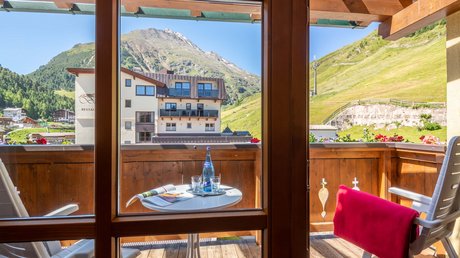 Des impressions de notre hôtel alpin à Vent ! Balcon avec vue sur les montagnes, table avec une bouteille d'eau et un magazine