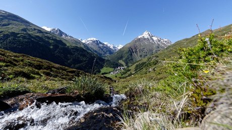 Des impressions de notre hôtel alpin à Vent ! Ruisseau de montagne coulant à travers une prairie alpine verte avec des sommets enneigés