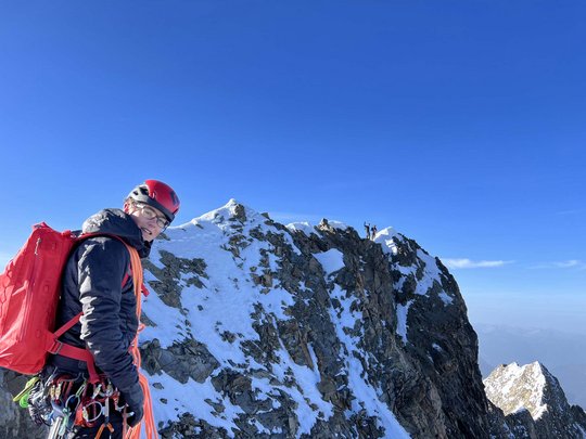 Sur le Similaun et la Wildspitze de notre hôtel à Vent Alpiniste avec équipement sur un sommet enneigé sous un ciel bleu clair