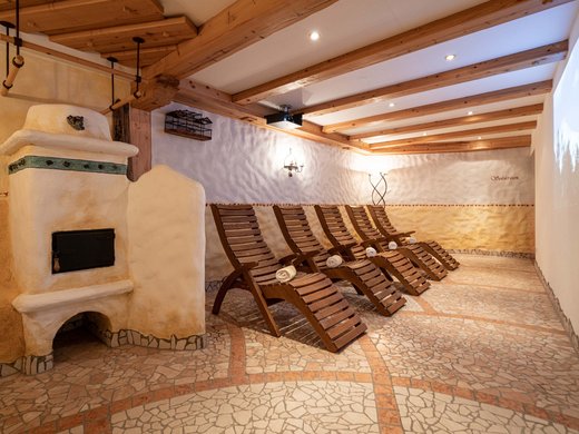 Das Wellnesshotel im Ötztal für Ruhesuchende Gemütlicher Ruheraum mit Holzstühlen und traditionellem Ofen