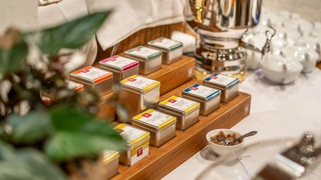 Impressionen aus unserem Natur- und Alpinhotel in Vent Teedosen in einem Holzständer und ein silberner Tee- oder Wasserkessel auf einem Tisch