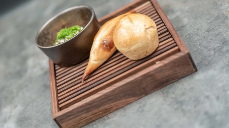 Des impressions de notre hôtel alpin à Vent ! Deux petits pains différents sur planche en bois avec beurre aux herbes dans bol