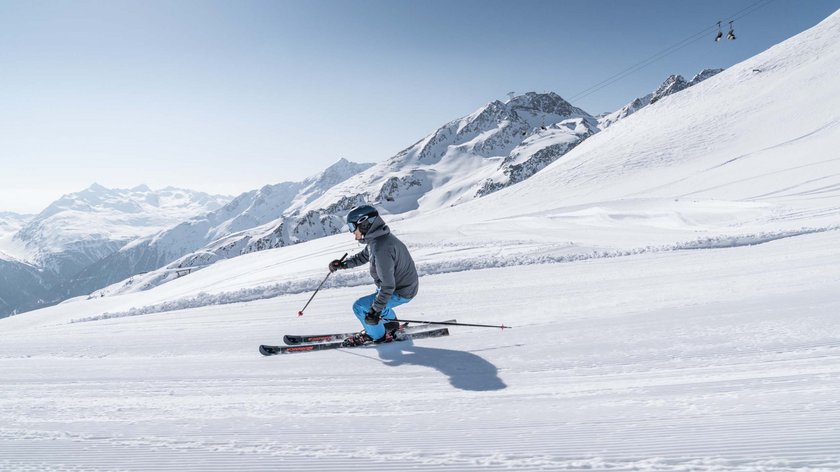 Skiing bliss without the bustle! Skier on freshly groomed slope in snowy Alpine mountains