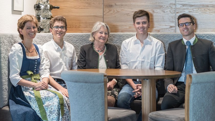 What drives us Five people sitting at a wooden table in a cozy setting