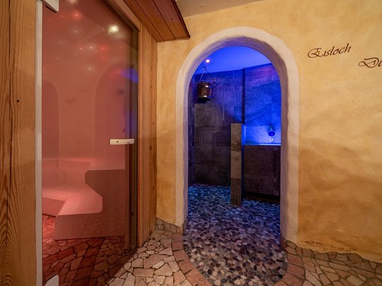 Sauna village & mountain lake: our hotel in Tyrol with pool Entrance to sauna and shower area with blue lighting